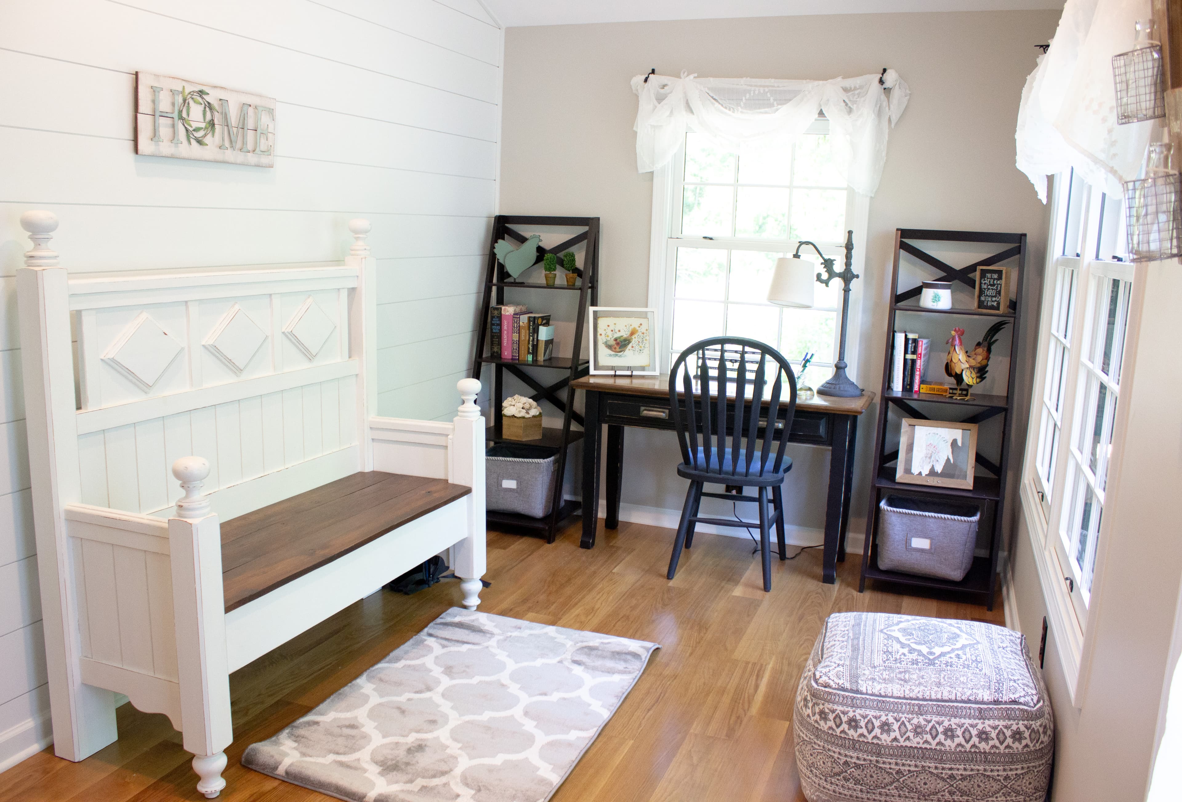 Quiet study and reading nook at The August House featuring a black writing desk, open shelving, a repurposed white farmhouse bench, and 'HOME' wall decor.