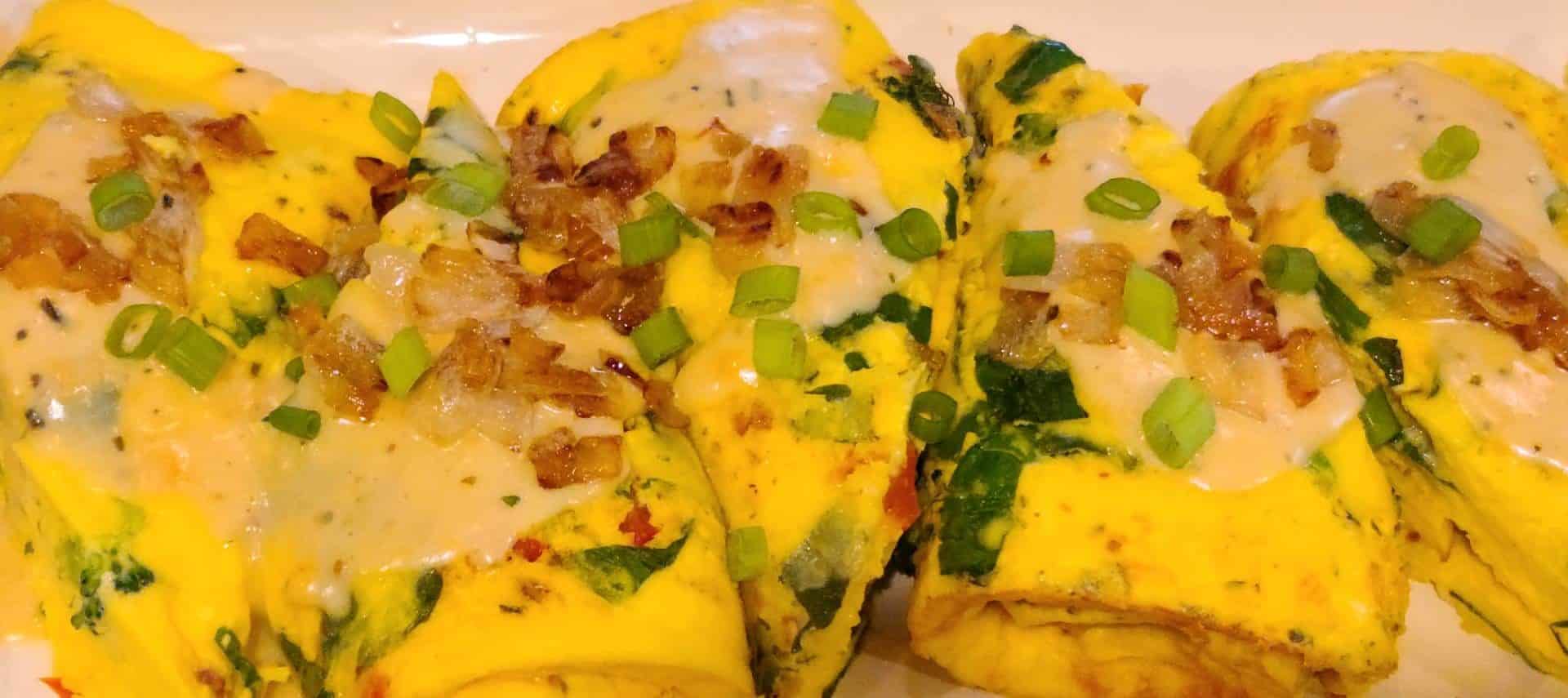 Close up view of omelettes covered with cheese, bacon, and onions