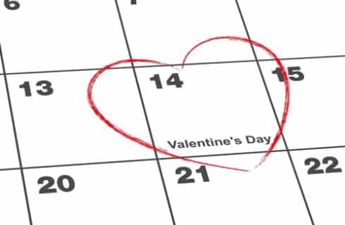 Close up view of a desk calendar with a red heart around day 14 for Valentine's day