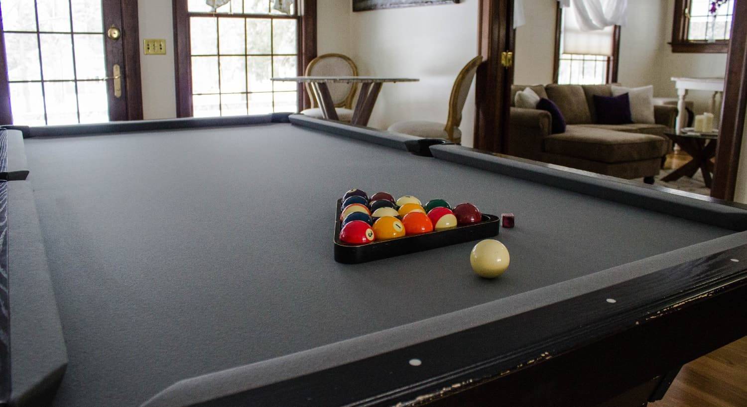 Close up view of a pool table with the balls in the rack